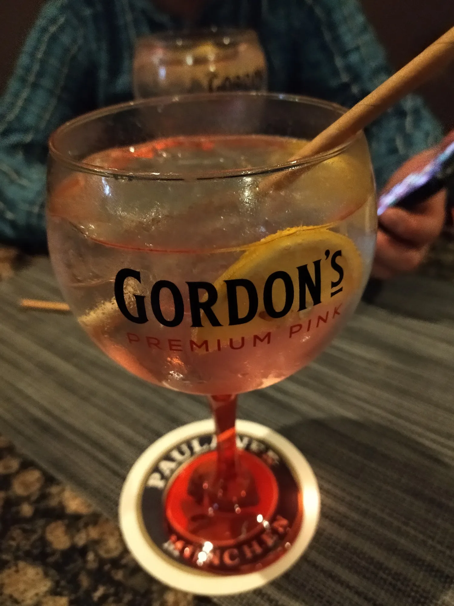 Pink Gin Tonic im Ballonglas auf einem Bierdeckel